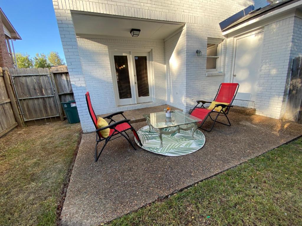 d'une terrasse avec 2 chaises et une table en verre. dans l'établissement Red Door North Jackson-Ridgeland Vacation Home, à Jackson