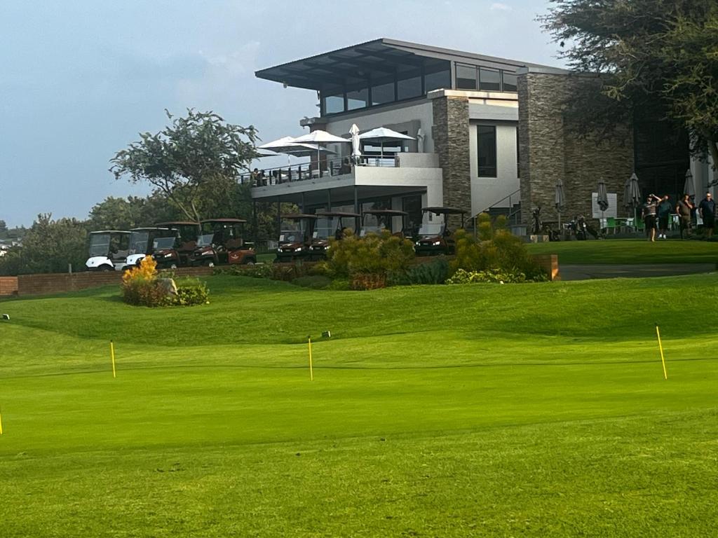 un campo de golf con una casa en el fondo en Jackal Creek Golf Estate en Roodepoort