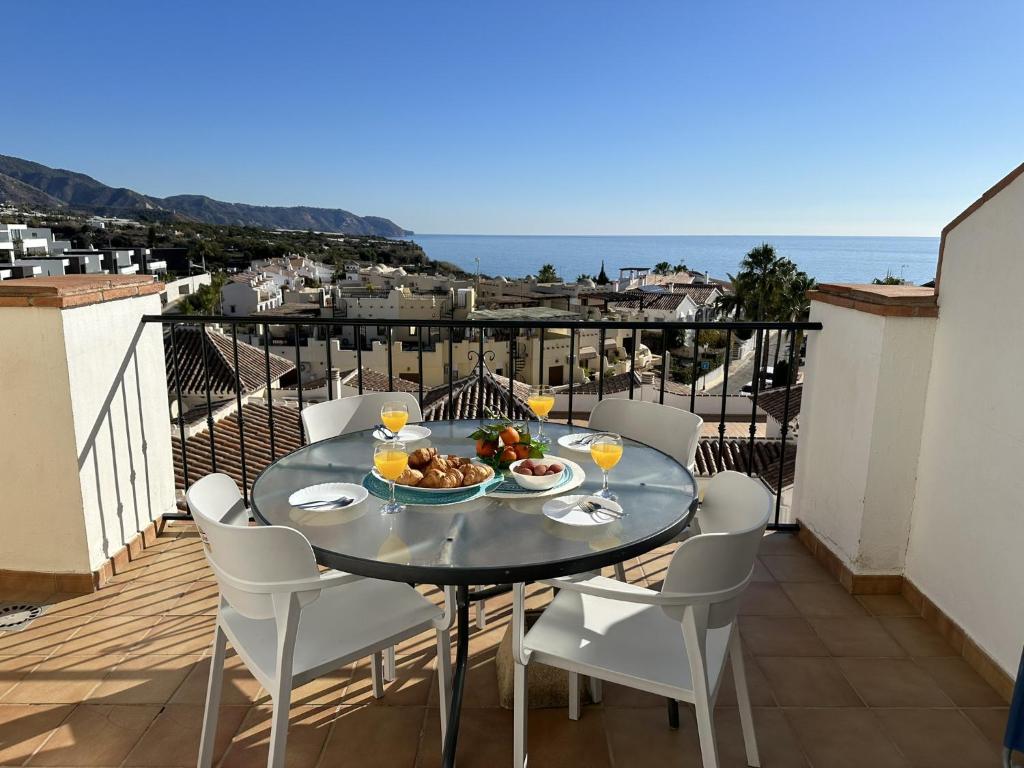einen Tisch mit einer Schüssel Essen auf dem Balkon in der Unterkunft Nerja Paradise Rentals - Apt Chimenea C2D in Nerja