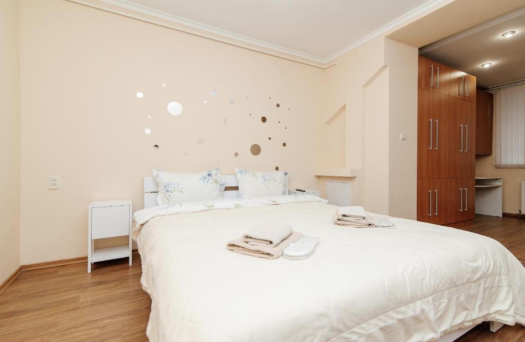 ein Schlafzimmer mit einem großen weißen Bett mit Handtüchern darauf in der Unterkunft Vieru in Chişinău