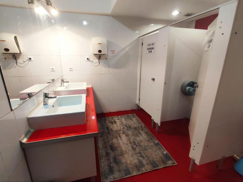 La salle de bains est pourvue d'un lavabo blanc et d'un comptoir rouge. dans l'établissement TRANSIT, à Istanbul