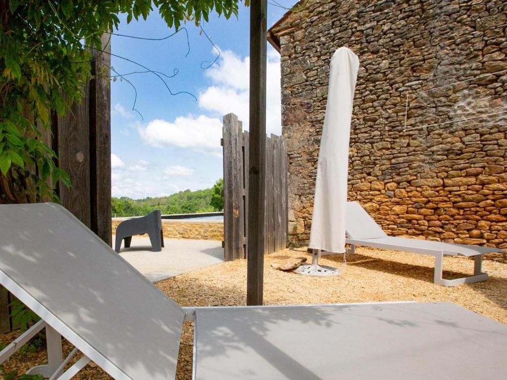 a white umbrella and a chair and an umbrella at Rustic holiday home in Loubejac with jacuzzi in Loubejac
