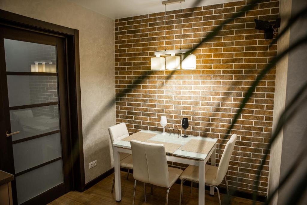 comedor con mesa y sillas contra una pared de ladrillo en Center Home Apartment, en Chişinău