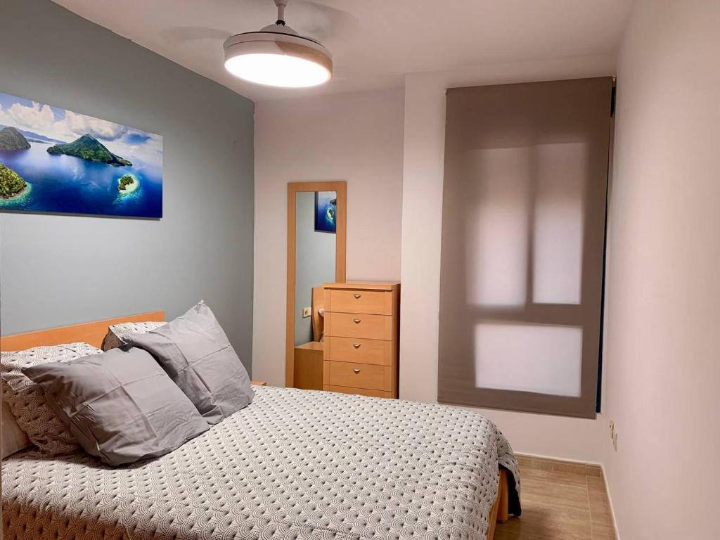 卡耐特蒂貝蘭格的住宿－Experience Valencia Bnb - Rincon del Mar - Apartamento Maravilloso a Canet Playa 100 mt，卧室配有一张床,墙上挂有绘画作品
