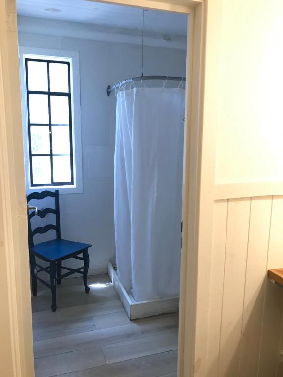 La salle de bains est pourvue d'un rideau de douche et d'une chaise. dans l'établissement El Trueque Ranch, à Santa Coloma