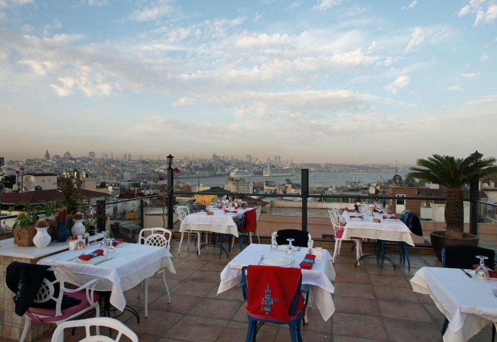 ein Restaurant mit Tischen und Stühlen und Stadtblick in der Unterkunft Raymond Hotel in Istanbul