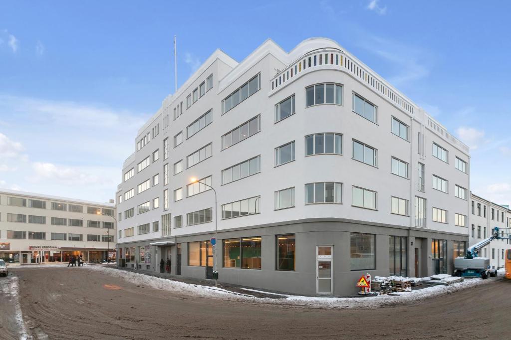 un gran edificio blanco en una calle de la ciudad en Hlemmur Suites, en Reikiavik