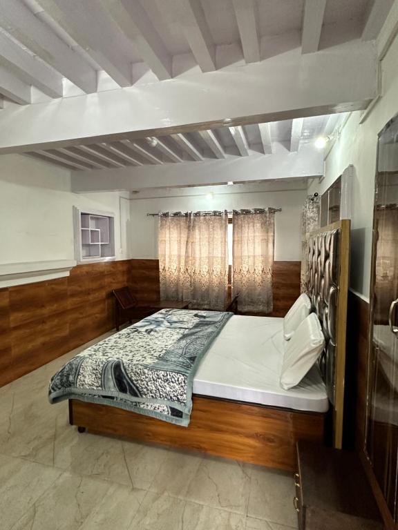 1 dormitorio con 1 cama grande en una habitación en MEHTA MANSION en Bhadarwāh