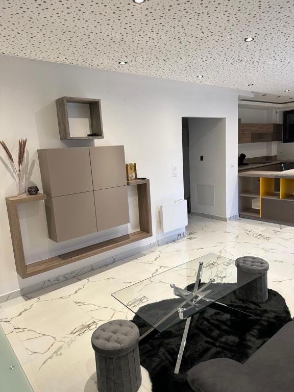a living room with a glass table and a kitchen at Appartement T3 Terrasse in Frontenex-Villard-Rosset