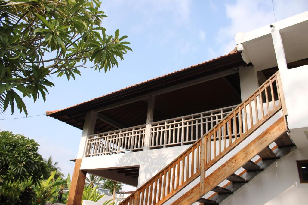 a balcony of a house with trees at Villa Kayu Padangbai in Padangbai