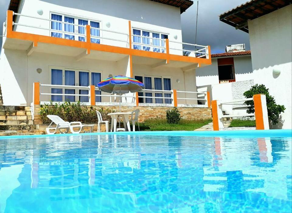 Villa con piscina frente a una casa en Pousada Aryanne, en Pecém