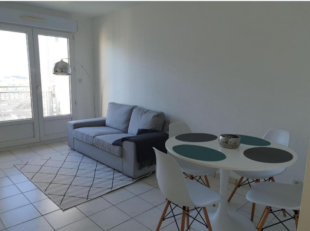 un salon avec un canapé, une table et des chaises dans l'établissement Le Triplex de la gare - centre ville - wifi, à Bordeaux