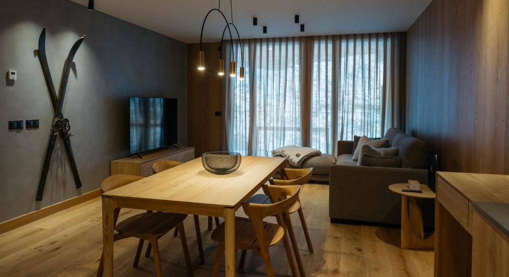 een keuken en een woonkamer met een tafel en stoelen bij ISARD RESIDENCES & SPA by Elegant Residences in El Tarter