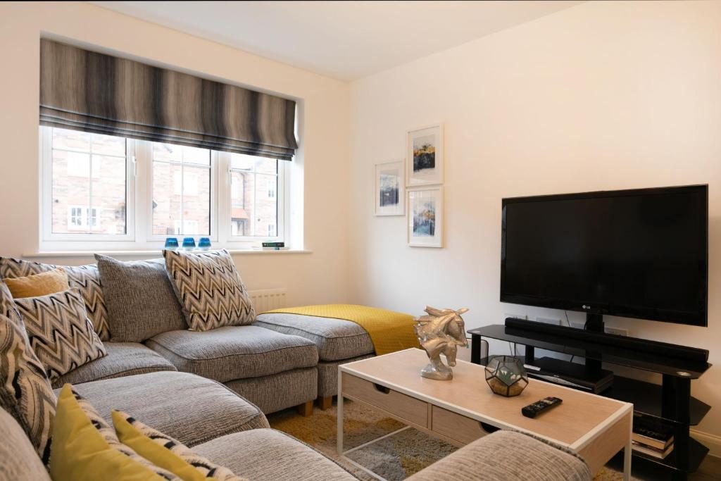 a living room with a couch and a flat screen tv at Jasmine House in Nottingham