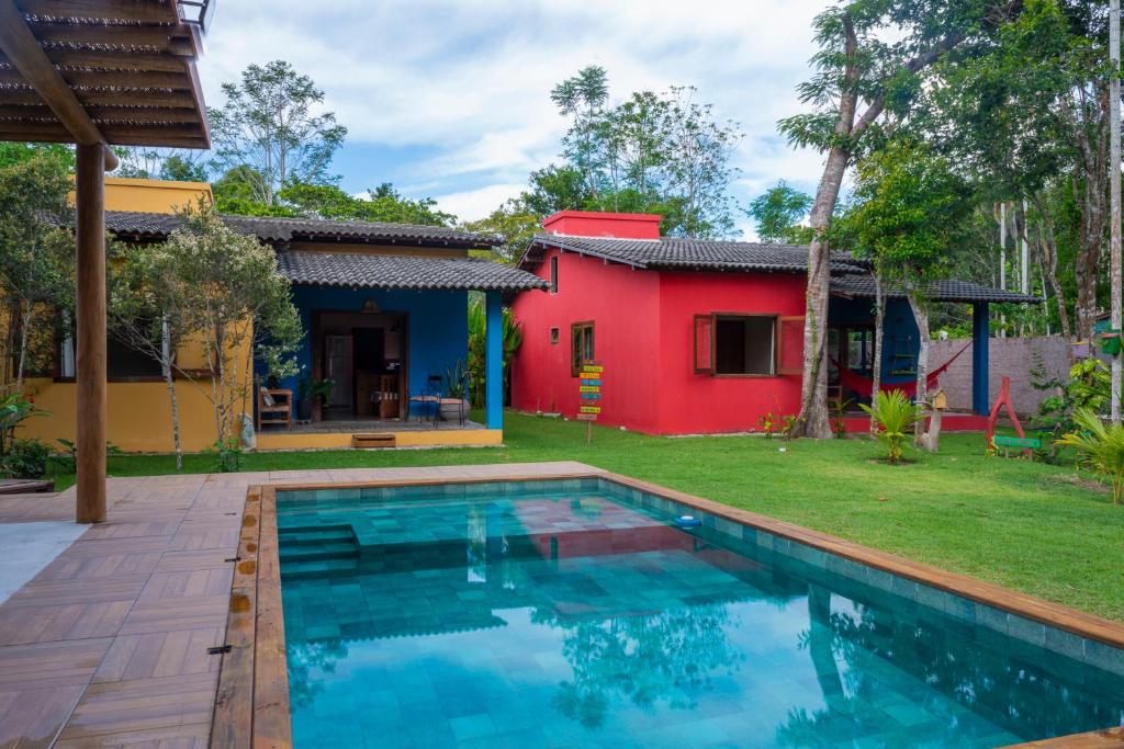 a house with a swimming pool in front of a yard at Quintal de Barros in Arraial d'Ajuda