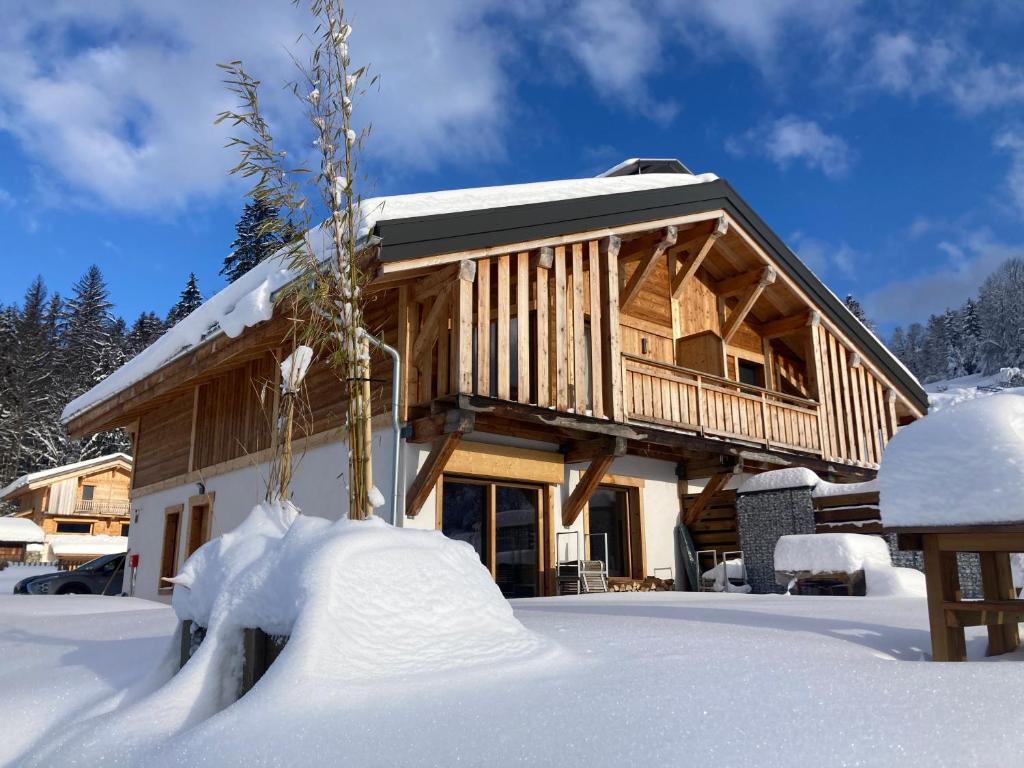 uma cabana de madeira na neve com neve à sua volta em Superbe Chalet à Megève 7 pers Près des Pistes em Demi-Quartier