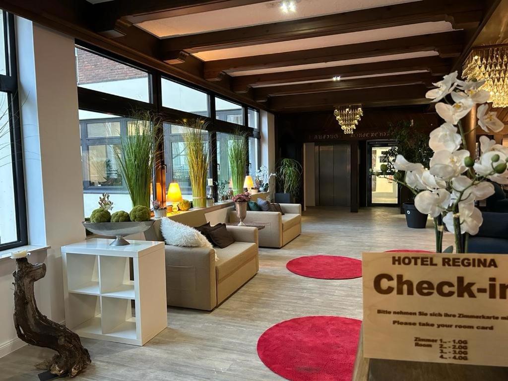um lobby com sofás e um balcão de check-in em Hotel Regina em Sankt Augustin
