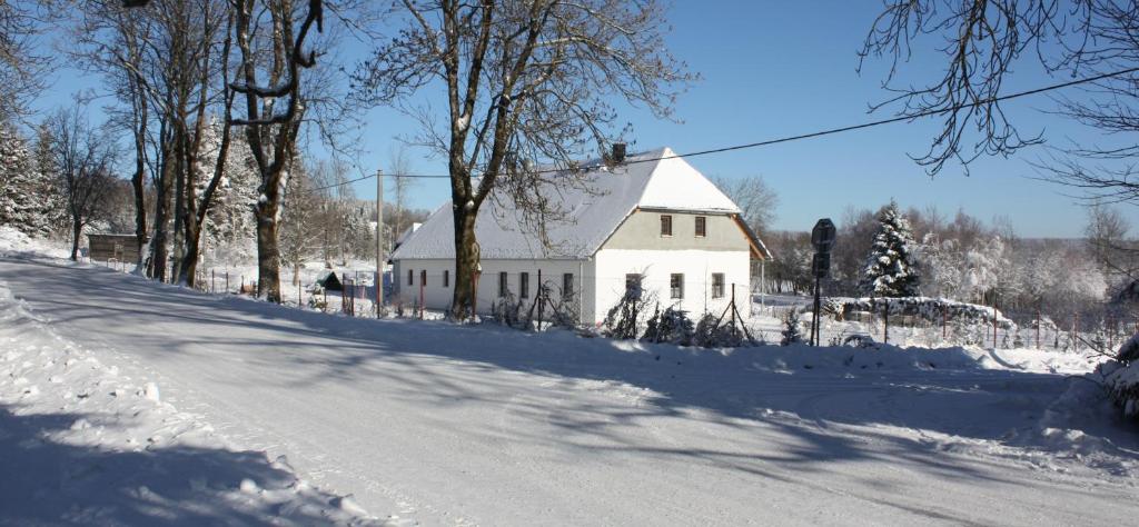 una carretera nevada con una casa blanca en el fondo en Chata Kaltenbach en Vimperk