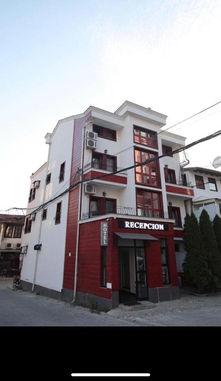 a red and white building with a sign on it at Best Hotel Zambaku i Bardhe in Prizren