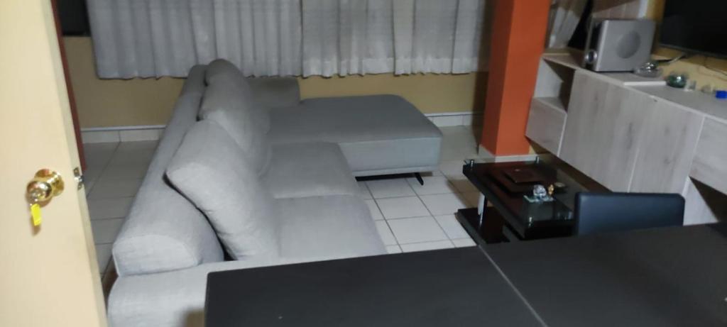 sala de estar con sofá blanco y TV en C & B APARTAMENTOS, en Jauja