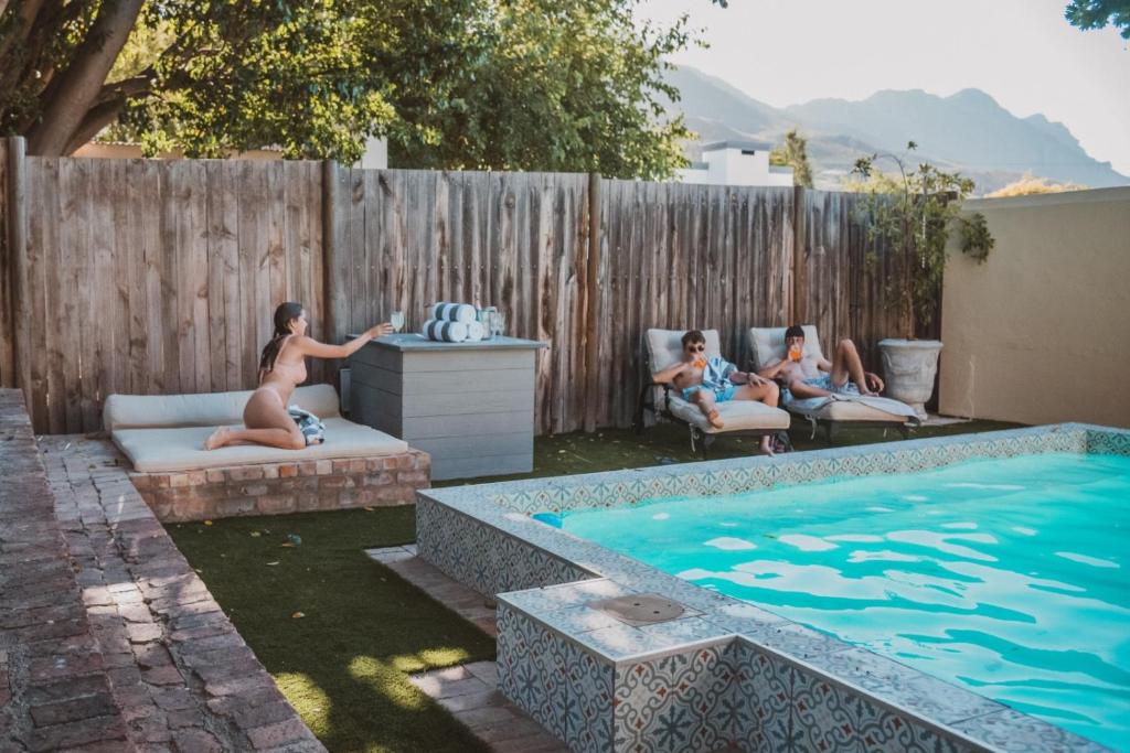 a group of people sitting around a swimming pool at Shades of Provence in Riebeek-Kasteel