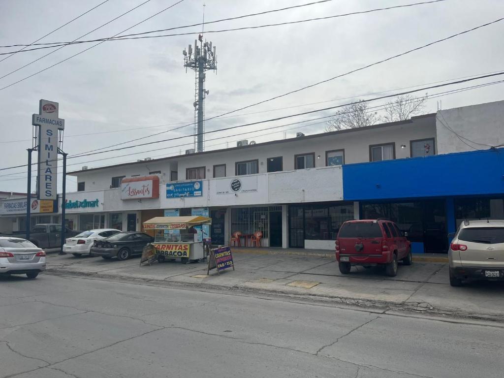 een gebouw met auto's geparkeerd op een parkeerplaats bij LOSSANTOS in Matamoros