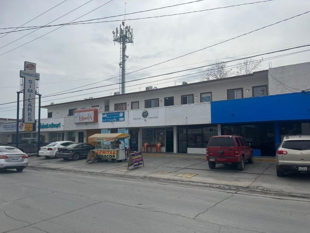 un bâtiment avec des voitures garées dans un parking dans l'établissement LOSSANTOS, à Matamoros
