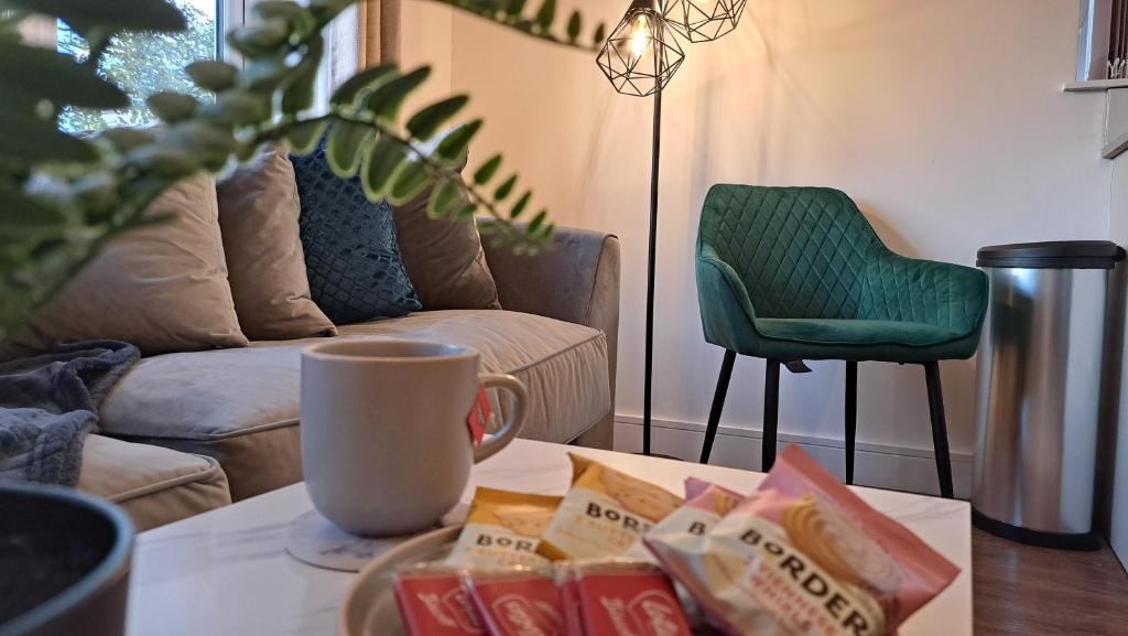 AT Evita Suites في كارديف: غرفة معيشة مع طاولة قهوة وكرسي أخضر