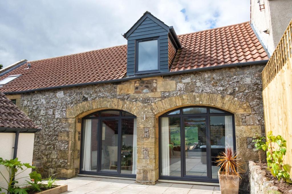 an extension to a stone house with black windows at Luxury Couple's Retreat with Hot Tub at Lindores in Newburgh