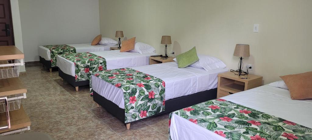 una habitación de hotel con 3 camas en una habitación en Casa 59 - Guest House, en Bucaramanga