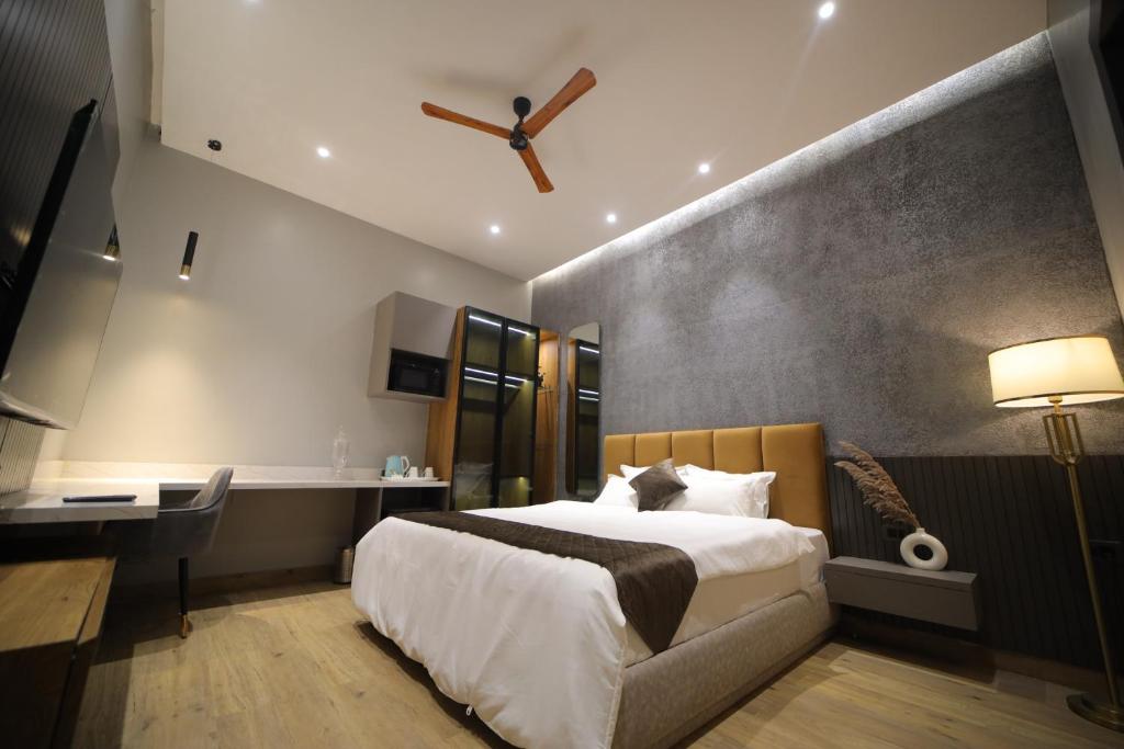 Habitación de hotel con cama, escritorio y reloj en The Cozy Chaos, en Agra