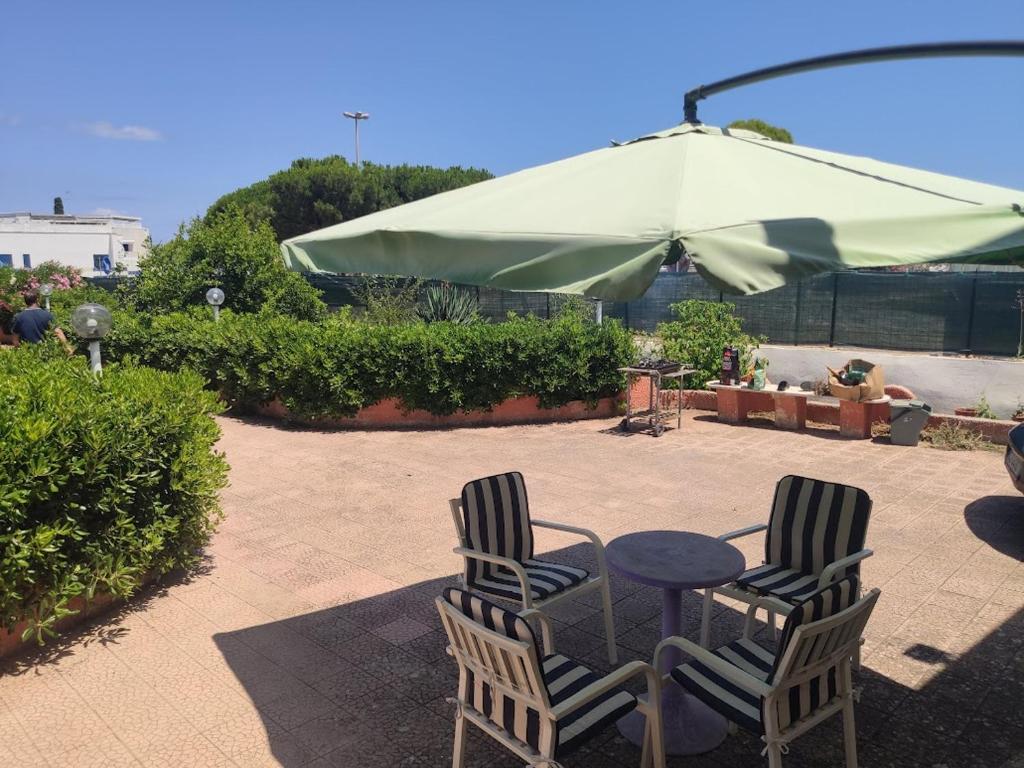 twee stoelen en een tafel en een groene paraplu bij Villa Crescenza in Mola di Bari