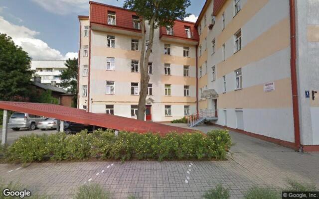 um banco vermelho em frente a um edifício em Nice&cozy flat No7 em Riga