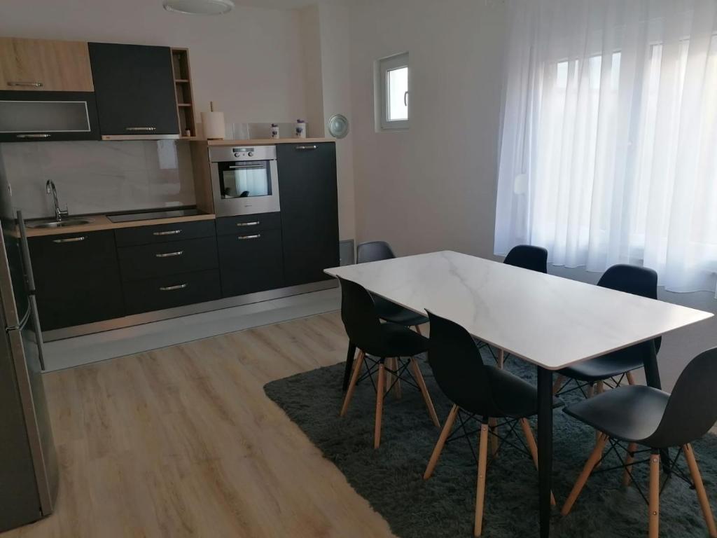 een keuken met een tafel en stoelen in een kamer bij Apartman STAR in Široki Brijeg