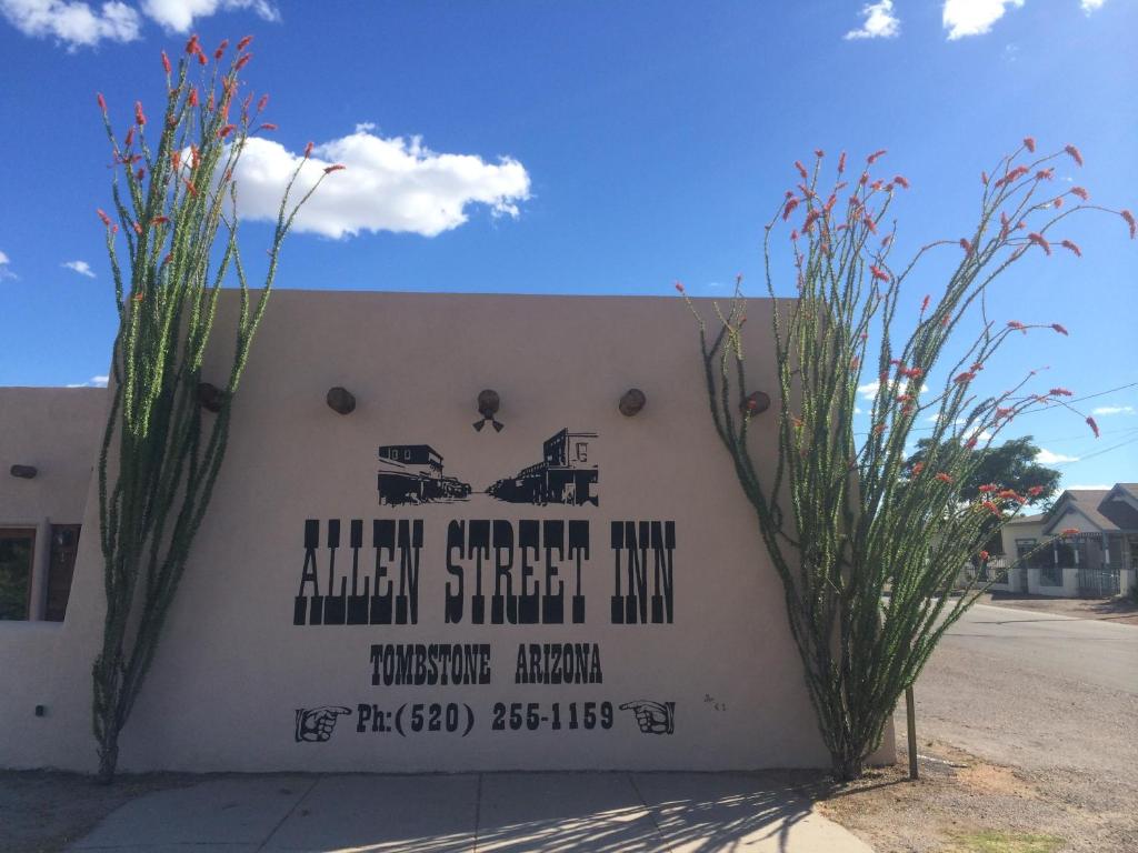 um sinal para a pousada da rua Alameda com algumas plantas em Allen Street Inn em Tombstone