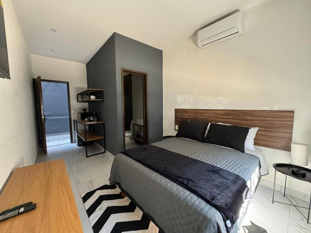 een slaapkamer met een bed, een tafel en een raam bij Vidrio Suites Col Americana in Guadalajara