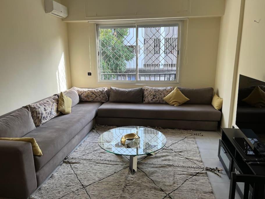 a living room with a couch and a glass table at Superbe appartement proche de toutes les commodité in Rabat