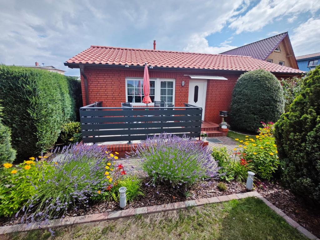 een klein huis met een zwarte bank in een tuin bij Ferienwohnung Hidde in Ostseebad Koserow