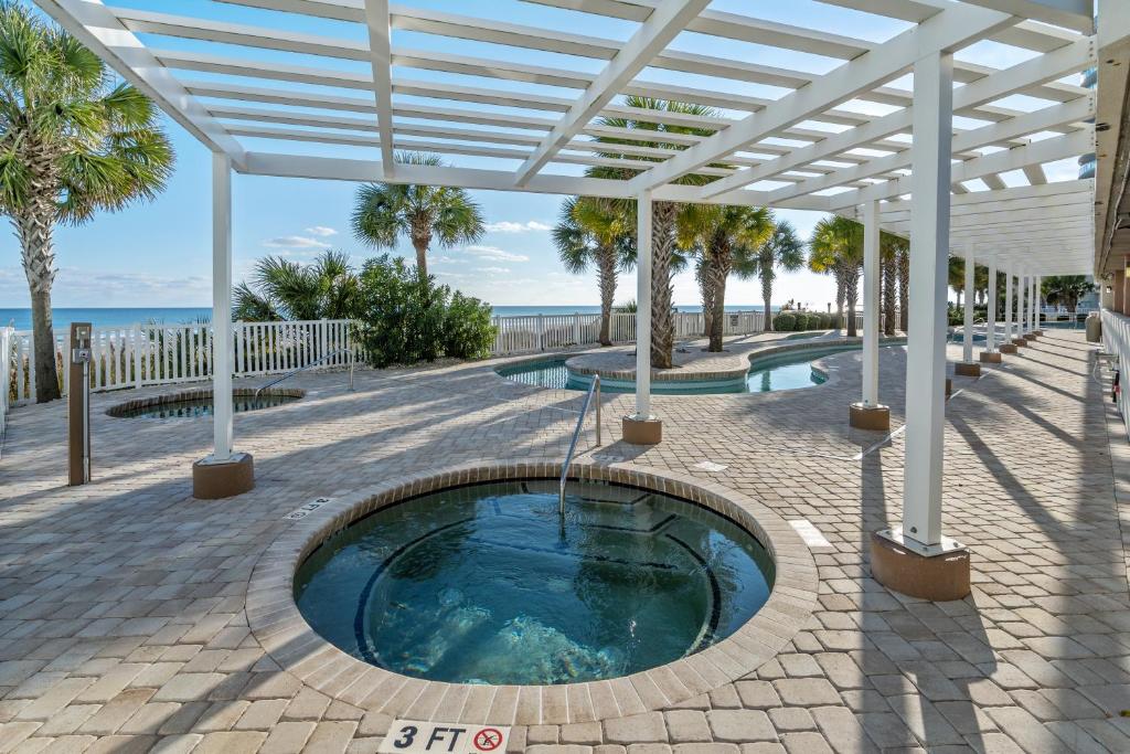 a hot tub in a pavilion with the ocean in the background at Oceanfront Get Away in Myrtle Beach