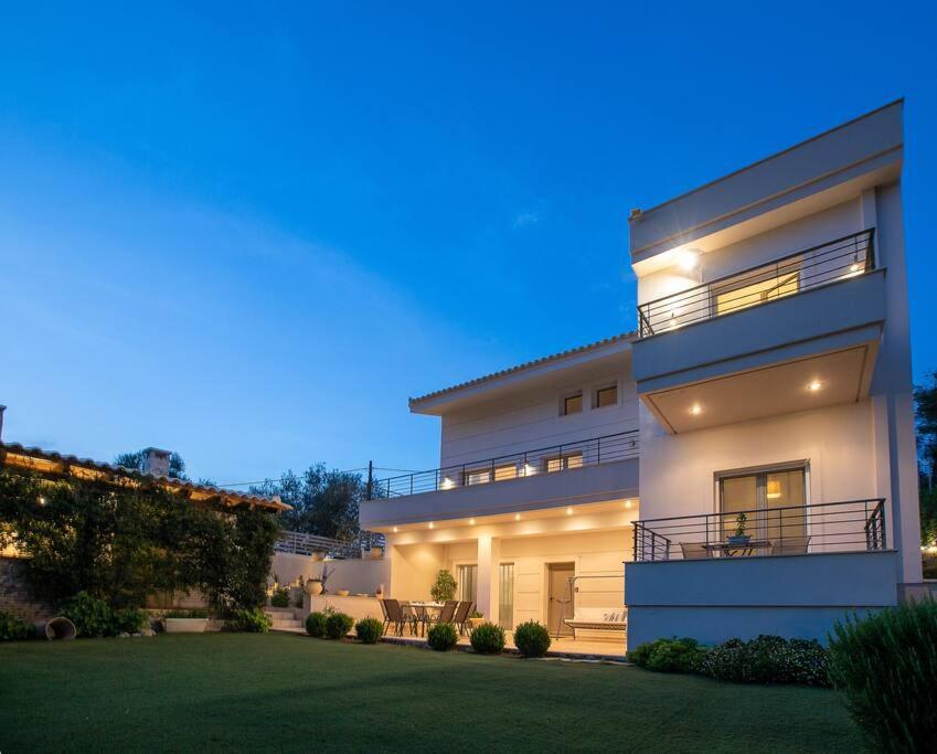 a large white building with a yard in front of it at Chillax House Near The Sea by Athenian Keys in Káto Alepokhórion