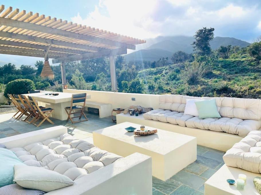 un salon avec des canapés blancs et une table dans l'établissement VILLA CARCO VECCHIO II, à Pietracorbara