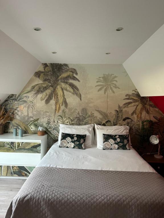 Port-Mort的住宿－Le relais du bord de seine，卧室配有一张大床,墙上挂着棕榈树