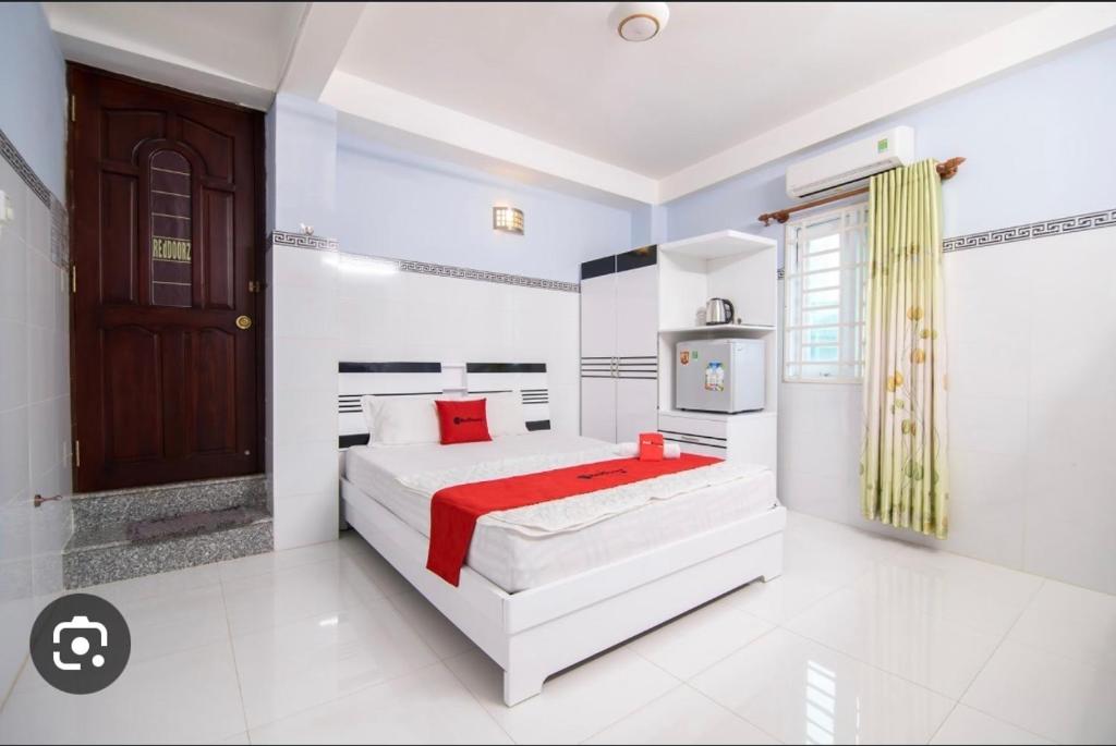 a white bedroom with two beds and a television at Rita Hotel Home- Airport Tân Sơn Nhất- Cạnh Bệnh Viện Tâm Anh & Gần Quân Khu 7 in Ho Chi Minh City