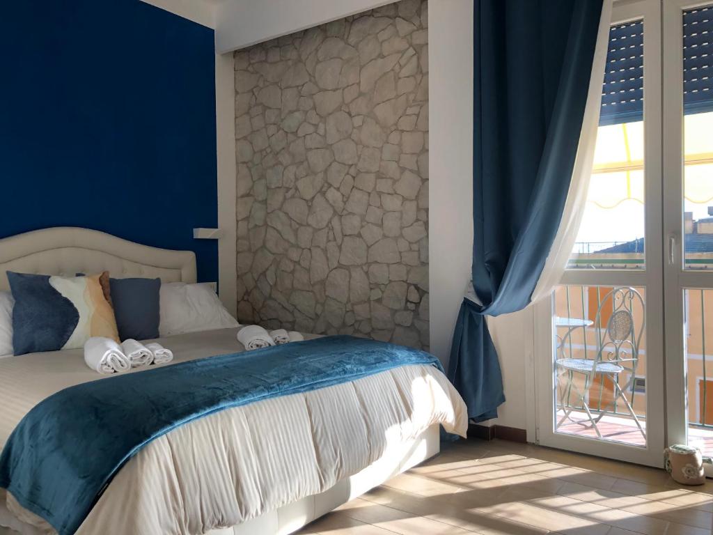 una camera da letto con un letto con pareti blu e un balcone di Il Sogno di Contardi A Affittacamere a Monterosso al Mare