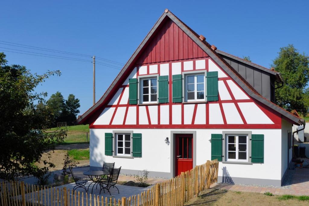 a red and white house with a red roof at Landluft Ferien - Wohnung Morgentau in Heiligenberg