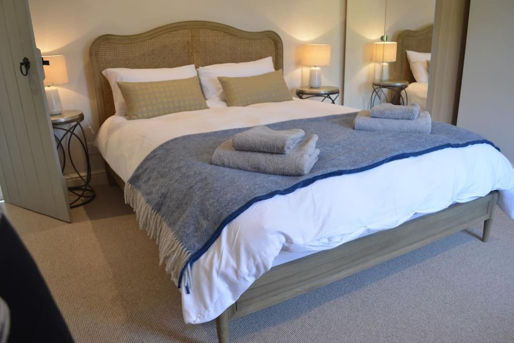 a bedroom with a large bed with two pillows at Owl's Hoot in Snettisham