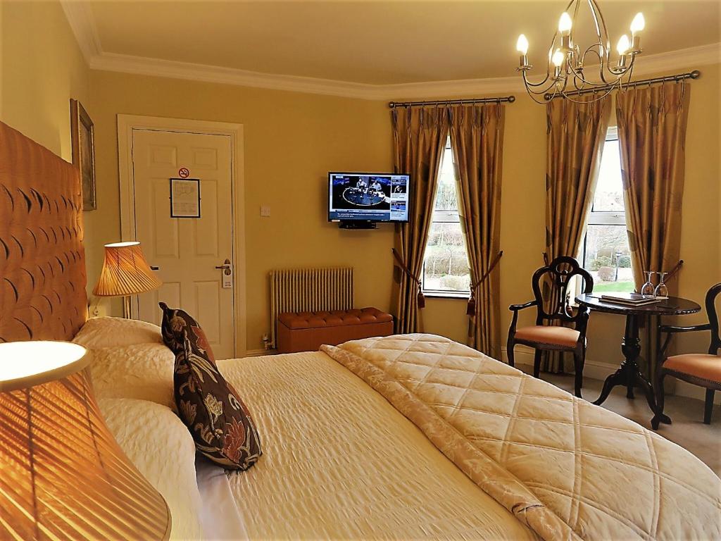 a bedroom with a bed and a television and a desk at Brook Manor Lodge in Tralee