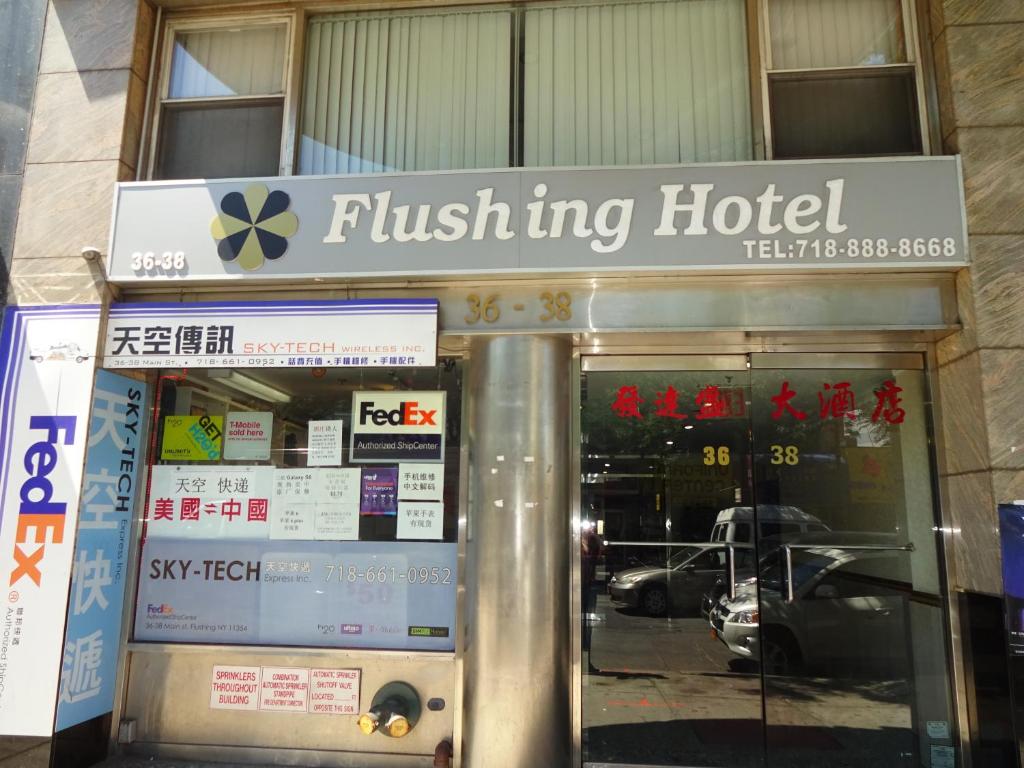 a flushking hotel sign in front of a building at Flushing Hotel in Queens