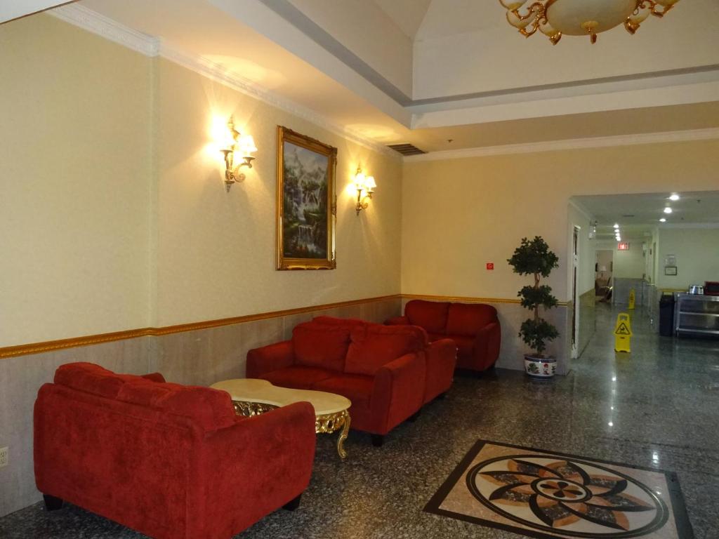 a living room with two red couches and a table at Flushing Hotel in Queens
