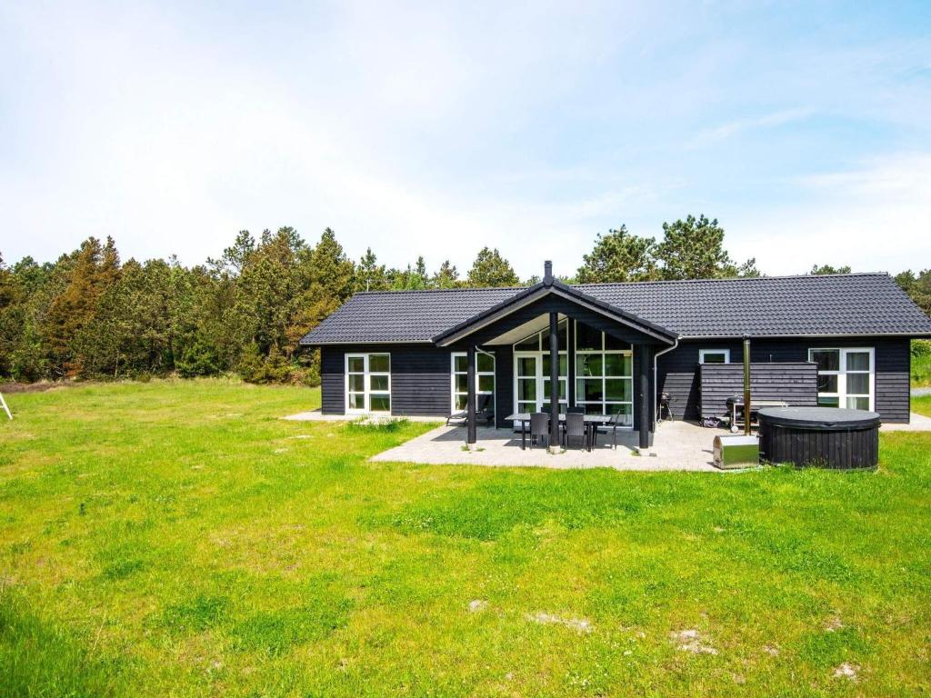 a small house with a large grassy yard at 12 person holiday home in R m in Rømø Kirkeby
